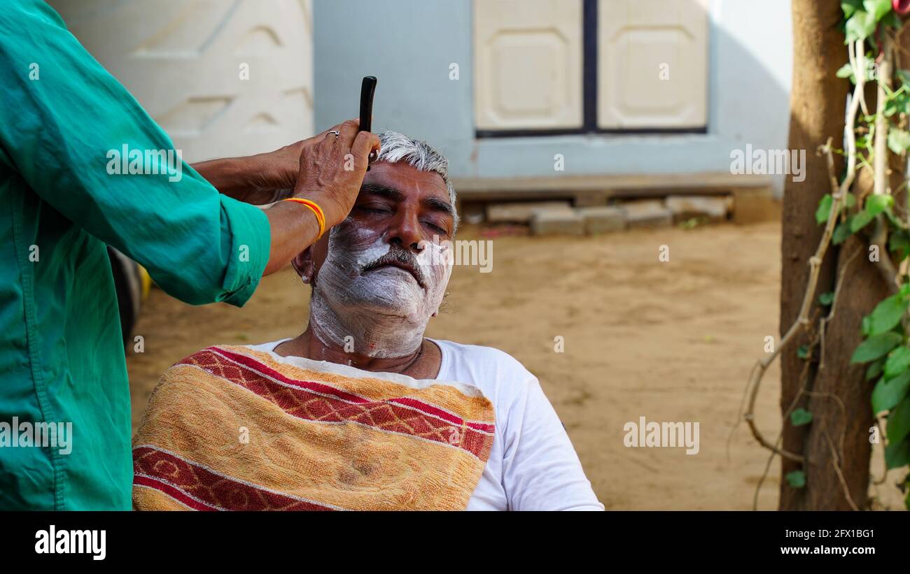 01 gennaio 2021 - Reengus, Sikar, India. Paesaggio rurale indiano, barbiere locale andare ogni giorno porta a porta per radere gli abitanti del villaggio. Foto Stock