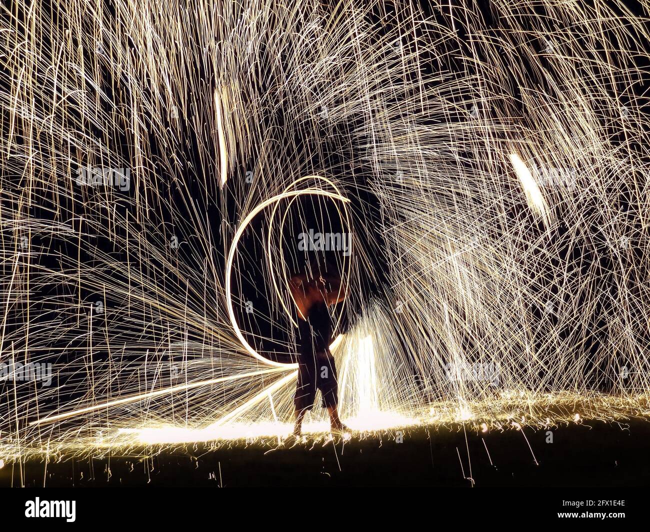 FIRESTARTER esibisce un incredibile spettacolo di fuoco con scintille di notte Foto Stock