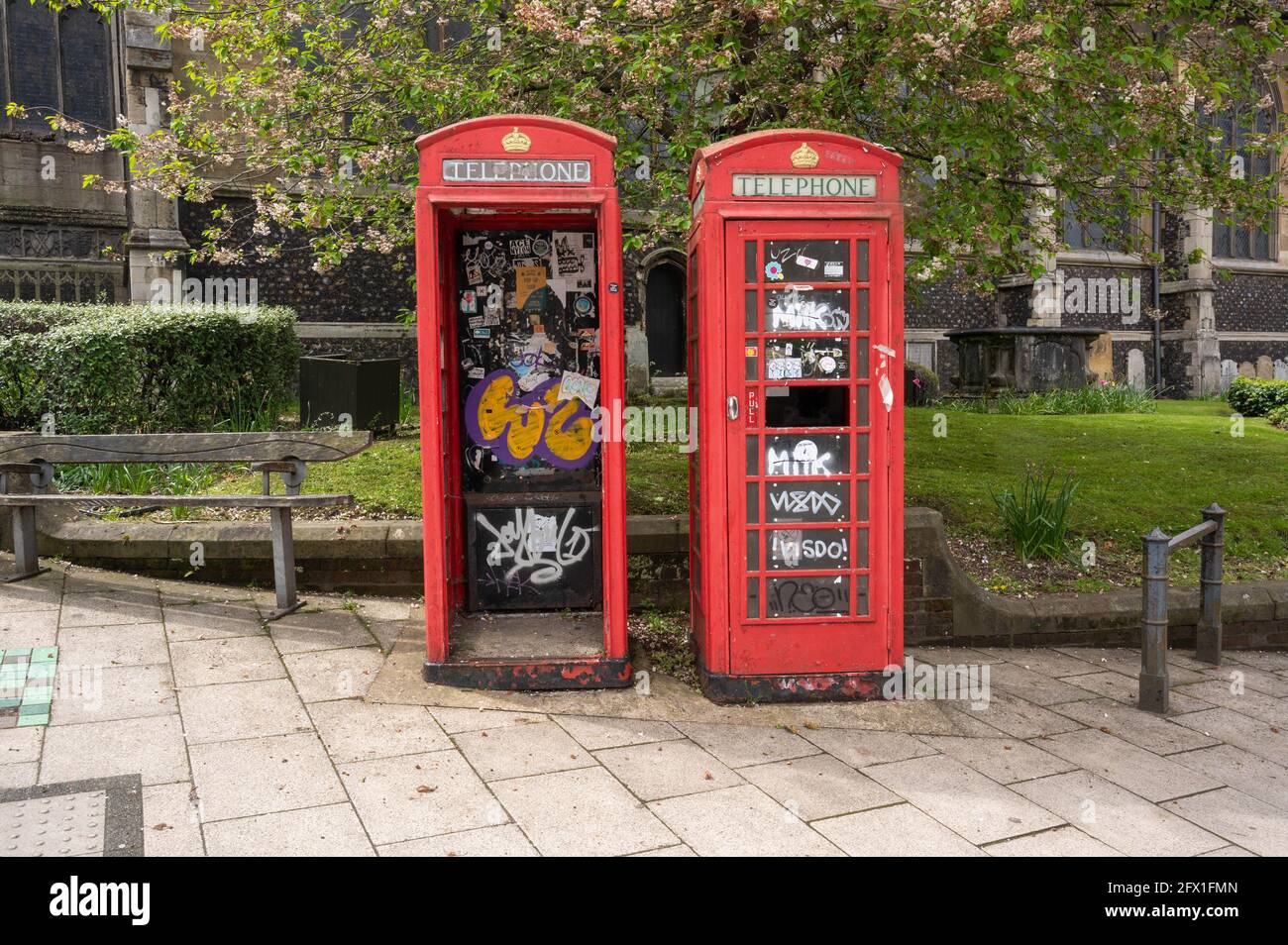 Due scatole telefoniche rosse di derelict vandilizzate l'una accanto all'altra con una porta mancante e il vetro schiacciato Foto Stock