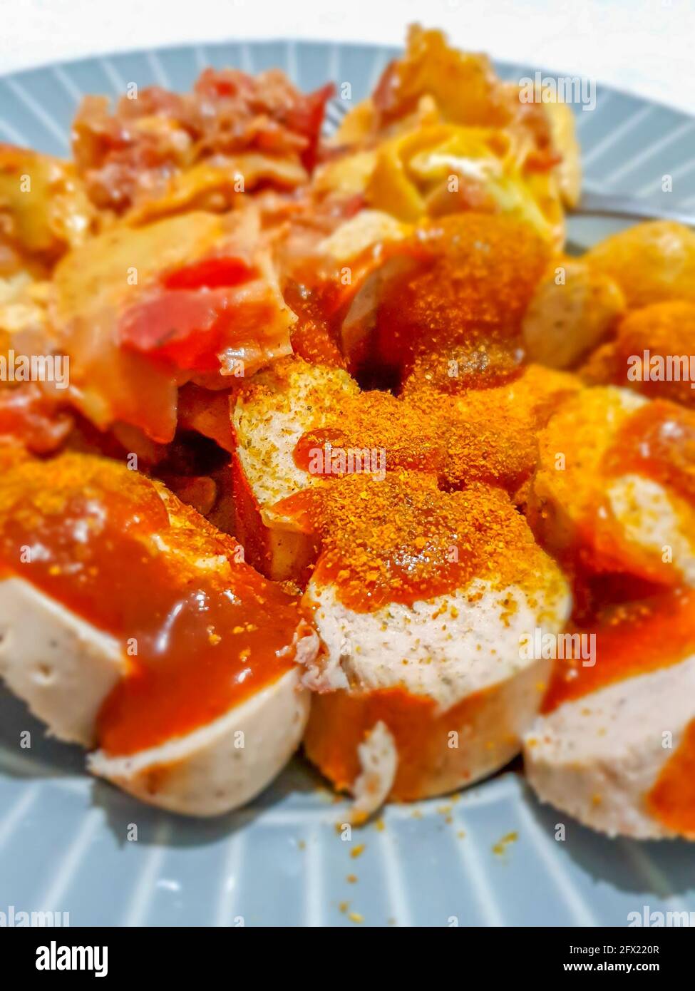 Currywurst tedesco - pezzi di bratwurst tedesco curry, salsiccia con ketchup e currypowder su un piatto Foto Stock