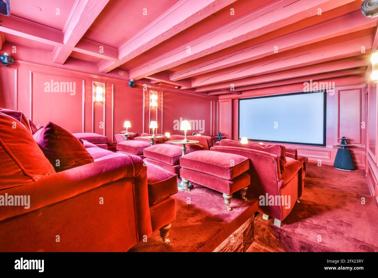 Camera di lusso di colore rosa con poltrone in velluto rosso al cinema sala di casa padronale Foto Stock