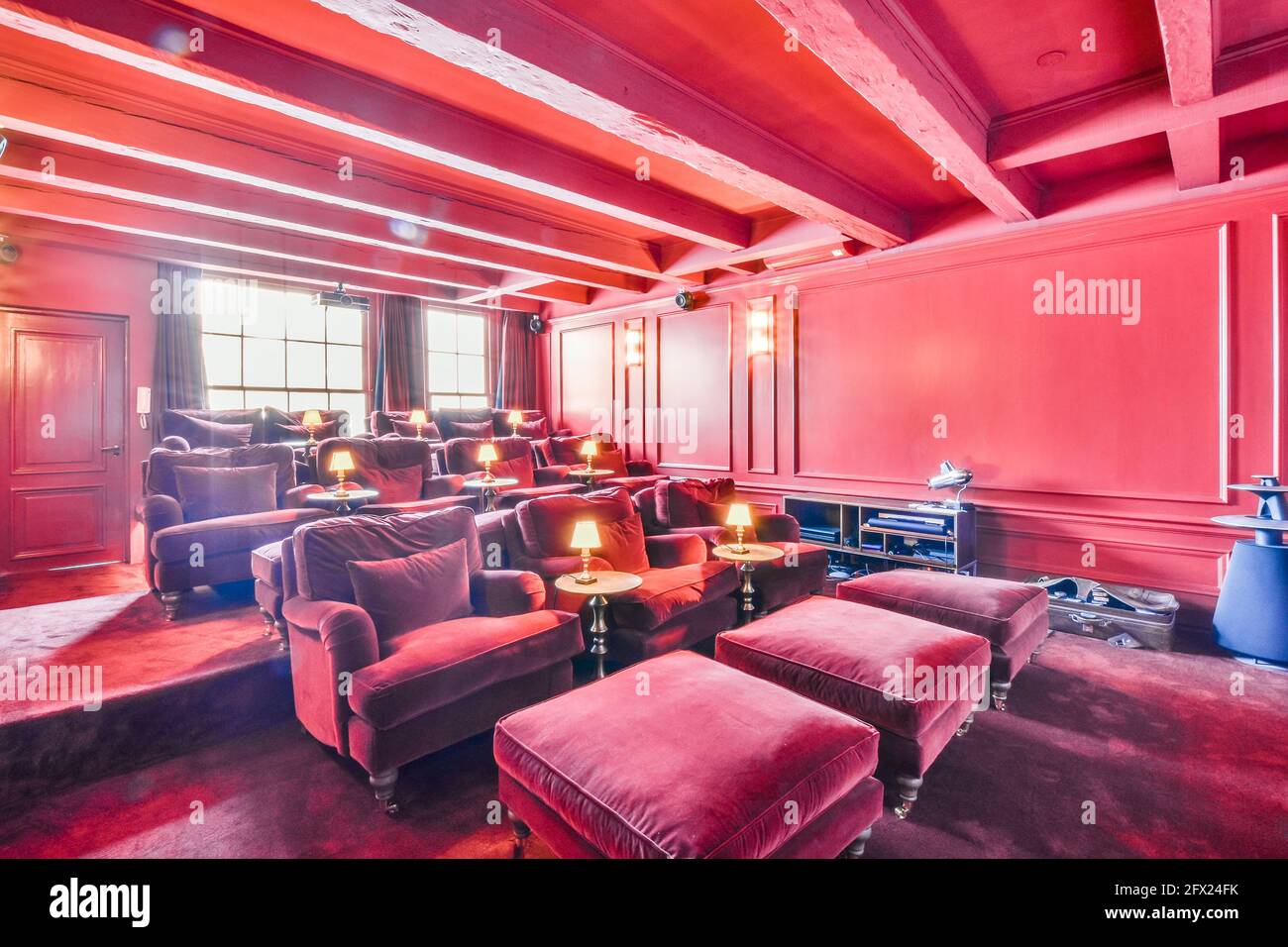 Camera di lusso di colore rosa con poltrone in velluto rosso al cinema sala di casa padronale Foto Stock