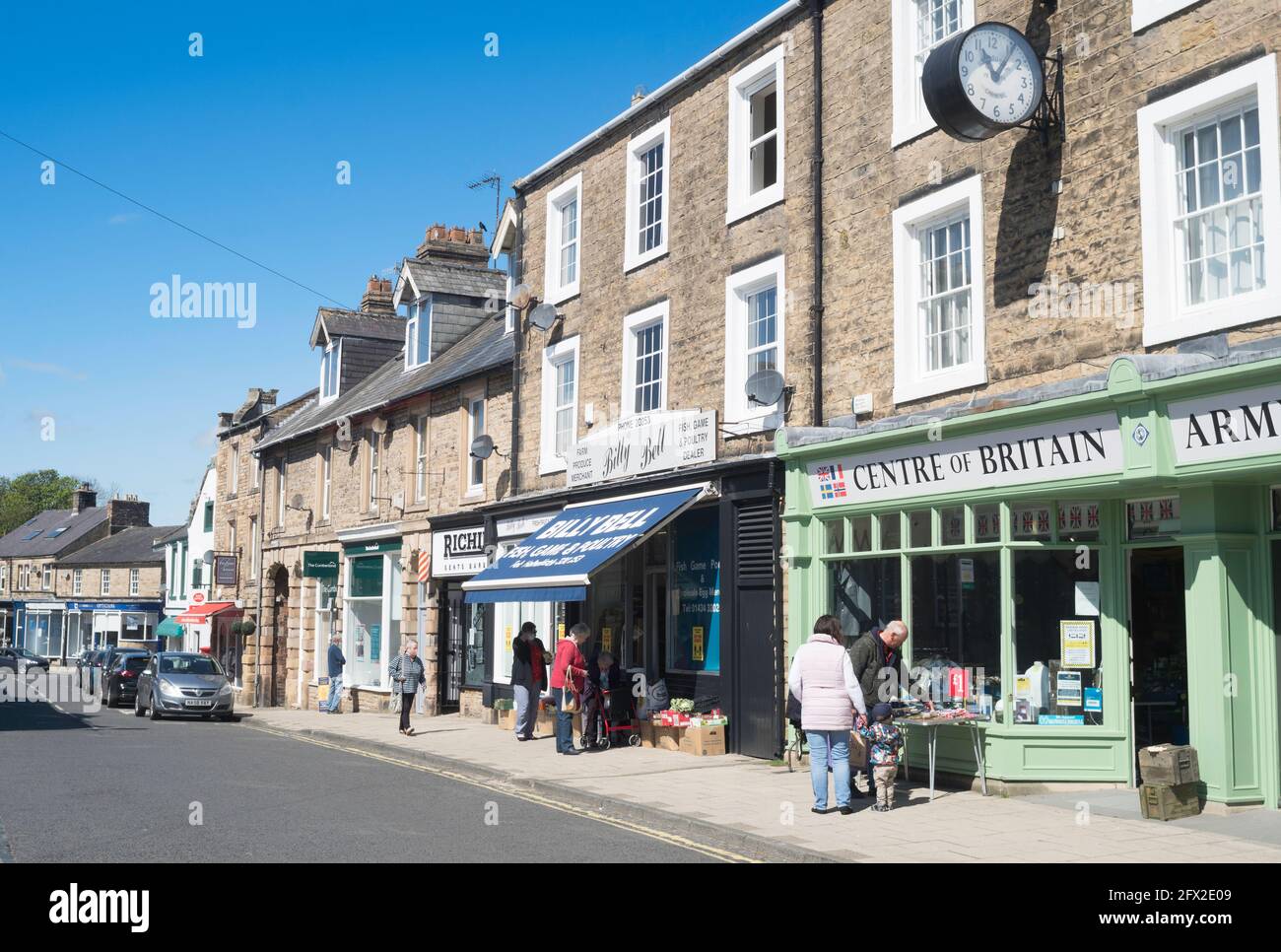 Le persone che acquistano nella piazza del mercato nel centro di Haltwhistle, Northumberland, Inghilterra, Regno Unito Foto Stock