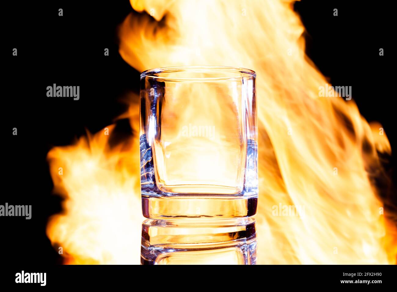 un bicchiere di brandy vuoto sullo sfondo del fuoco, posizionarlo sotto il testo Foto Stock