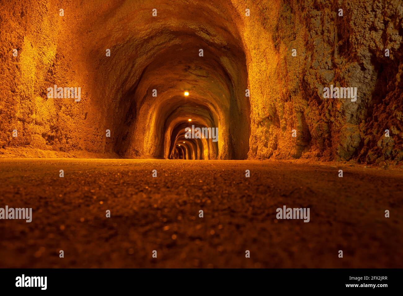 Tunnel pedonale di montagna con illuminazione medievale. Tunnel illuminato costiero a Rafailovici Montenegro Foto Stock