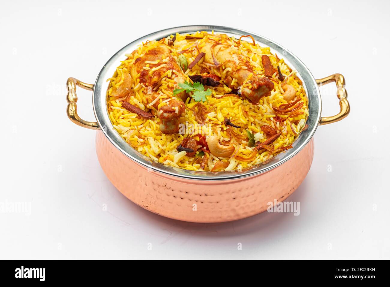 Pollo biryani , kerala stile pollo dhum biriyani fatto con riso jeera e spezie disposti in una ciotola di ottone con fondo bianco, isolare Foto Stock