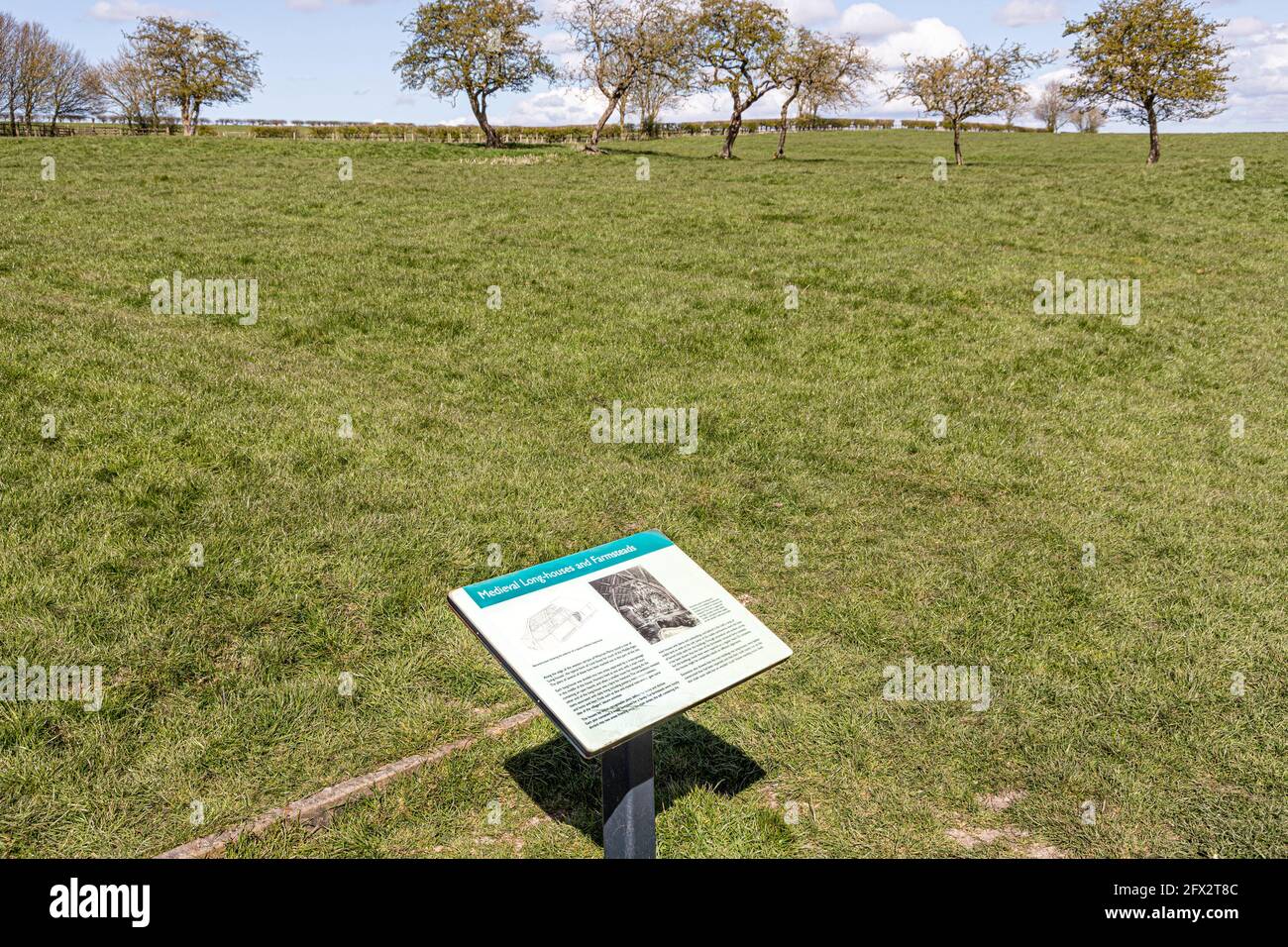 Wharram Percy deserted Medieval Village on the Yorkshire Wolds, North Yorkshire, England UK - pannello interpretativo sul sito delle case perdute. Foto Stock
