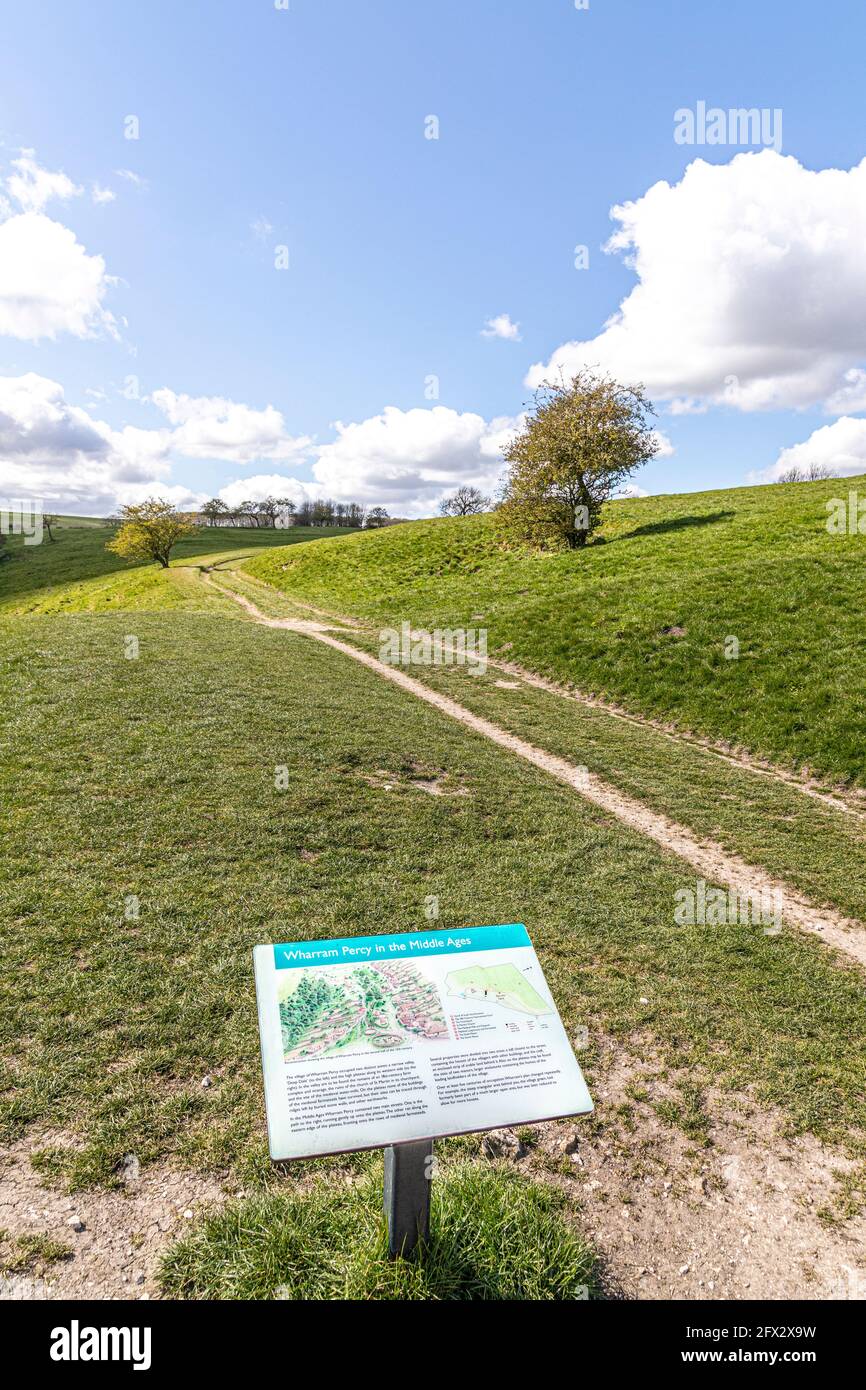 Wharram Percy deserted Medieval Village sul Yorkshire Wolds, North Yorkshire, Inghilterra UK - le abitazioni abbandonate erano sulla collina fino alla risata Foto Stock