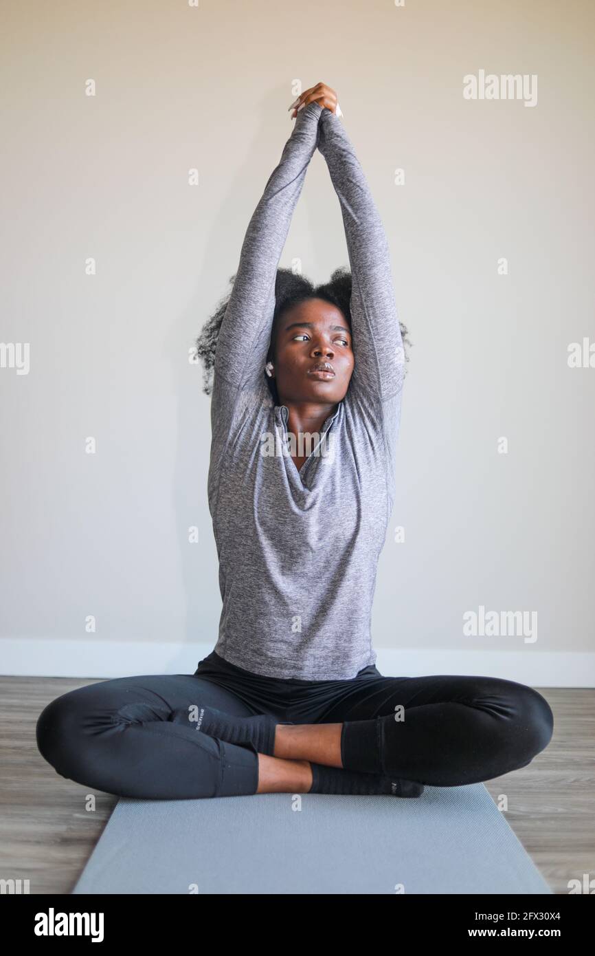 Giovane donna nera che fa yoga a casa, tappetino yoga, una persona, primo piano, meditazione relax, sfondo sfocato, afroamericano, modello nero, bello Foto Stock