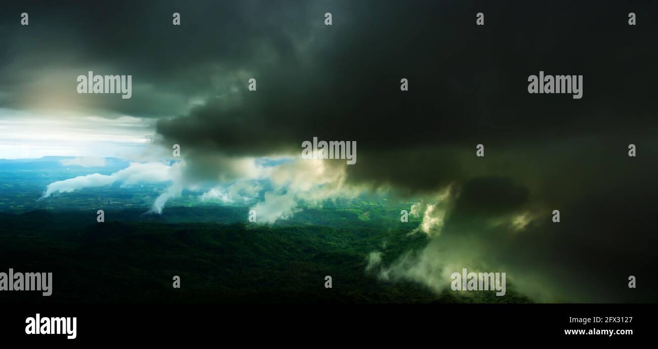 Sfocatura del movimento. Drammatiche nubi di tempesta scura su una foresta verde e montagne. Ambiente, concetti di cambiamento climatico. Foto Stock