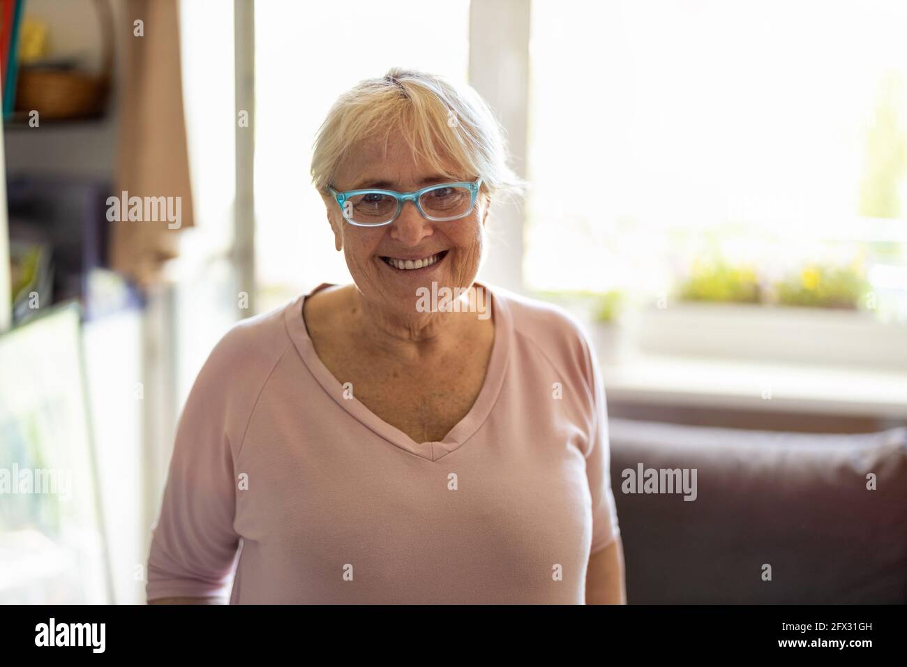 Felice donna anziana sorridente a casa Foto Stock