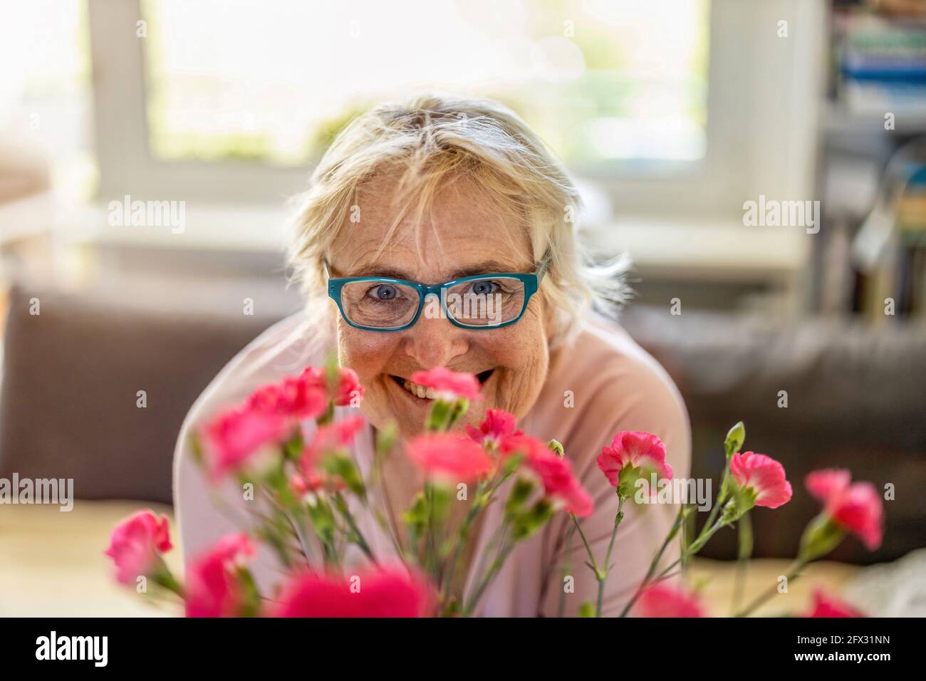 Felice donna anziana sorridente a casa Foto Stock