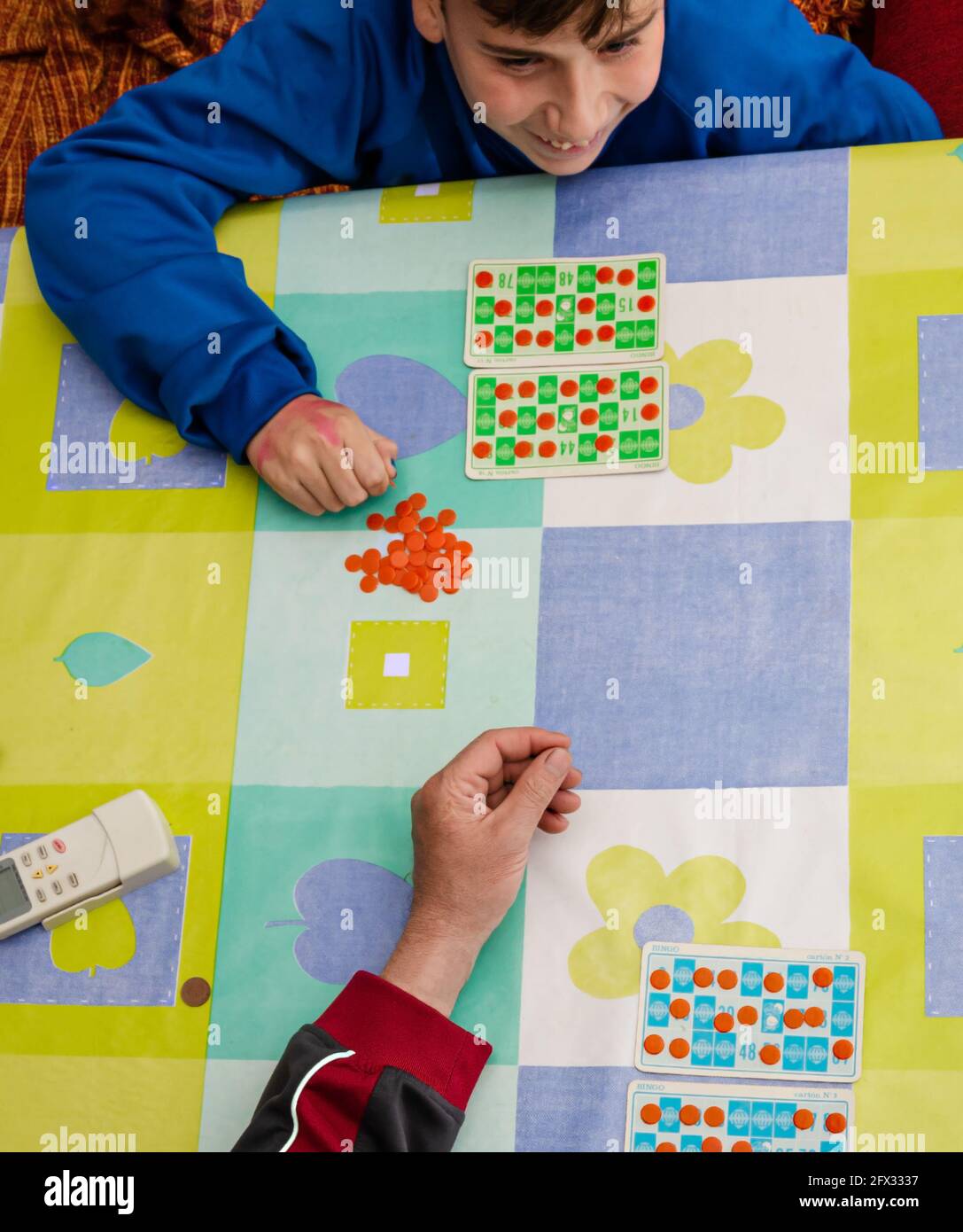 Una vista dall'alto di un adolescente caucasico sorridente che gioca a. gioco della lotteria con un membro della famiglia Foto Stock