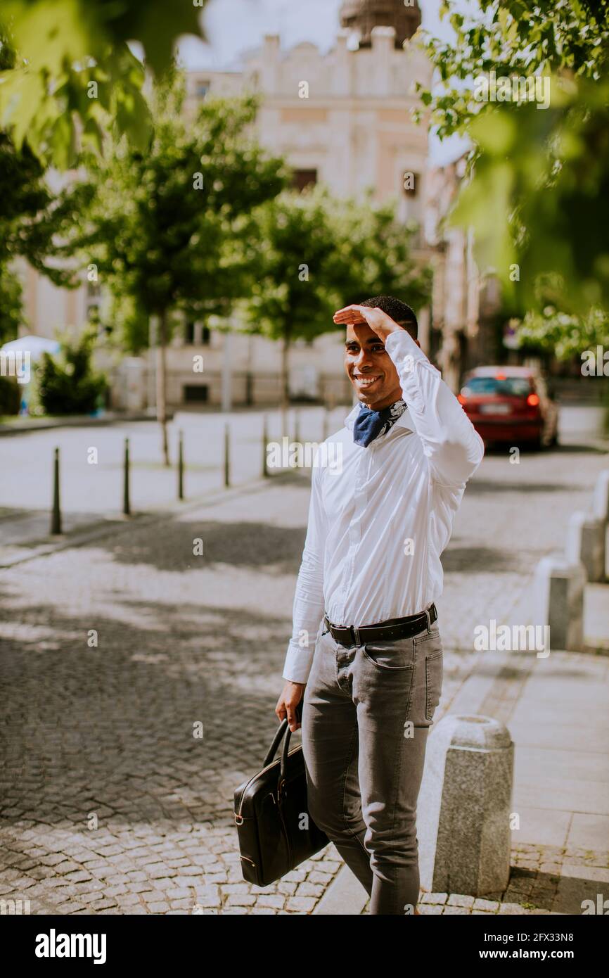 Bell'uomo d'affari afro-americano che ha in attesa di un taxi su un via Foto Stock