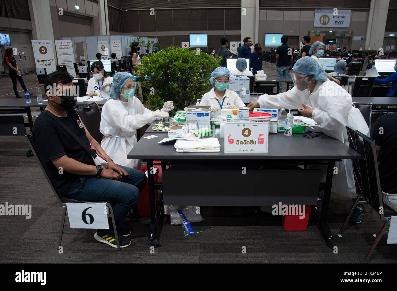 Bangkok, Thailandia. 25 Maggio 2021. Un uomo che indossa una maschera attende di essere vaccinato con il vaccino Sinovac durante la vaccinazione contro la malattia di coronavirus COVID-19 per i membri dell'equipaggio e i dipendenti di compagnie aeree commerciali al centro commerciale Siam Paragon a Bangkok. Credit: SOPA Images Limited/Alamy Live News Foto Stock