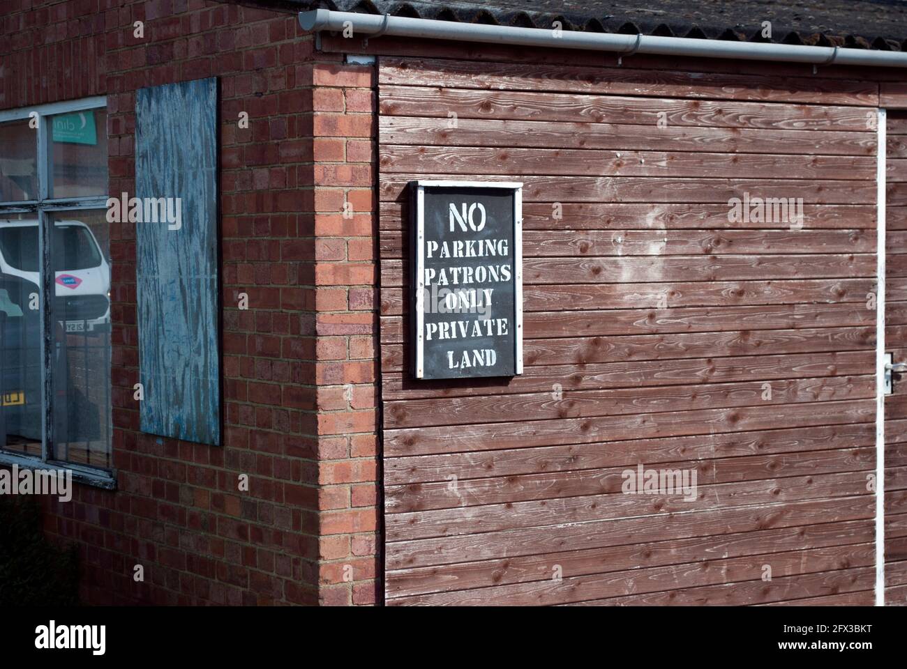 No Parcheggio solo i clienti Private Land segno sul lato di un edificio Foto Stock