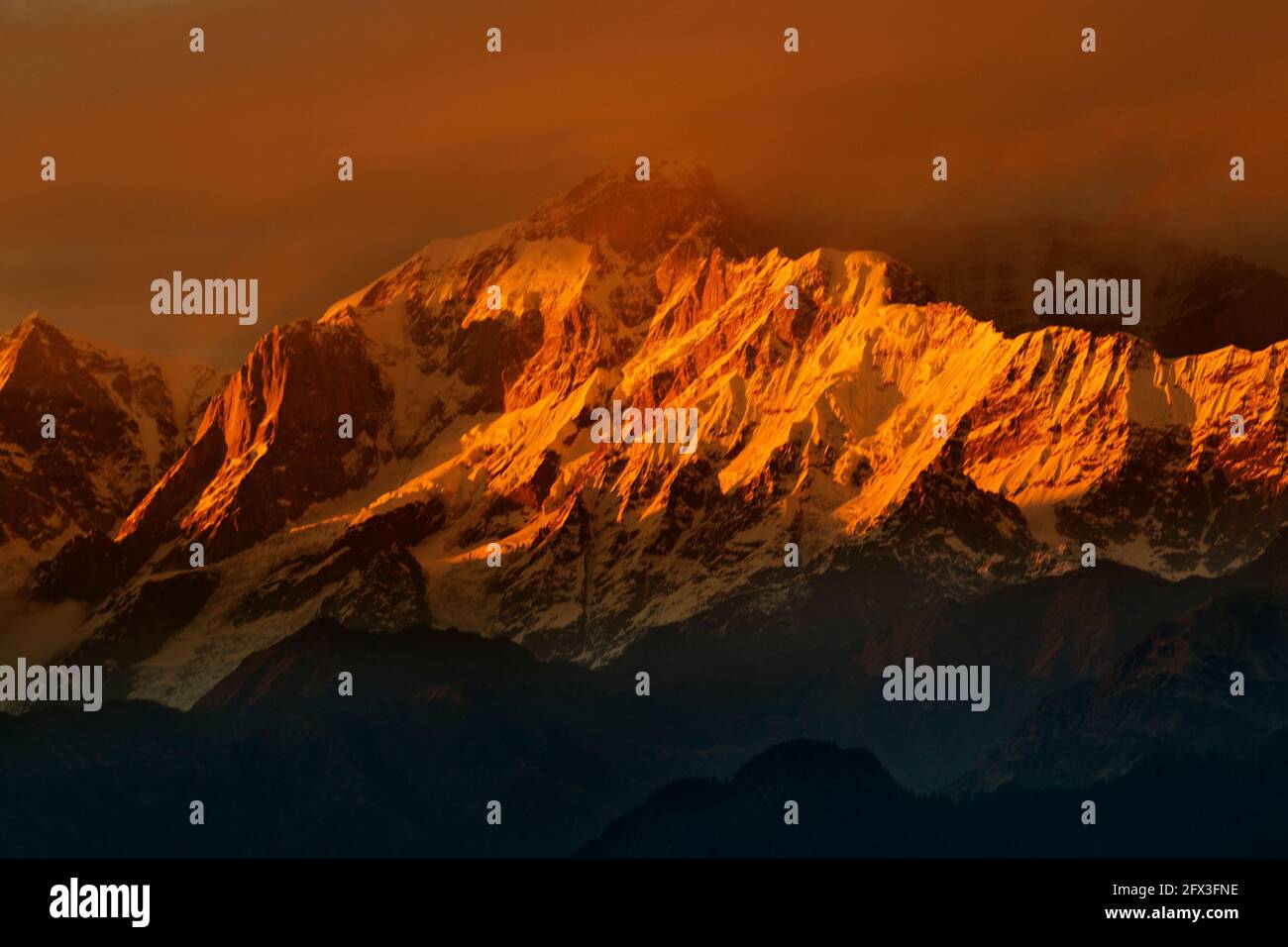 Tramonto arancione sulle cime di Chaukhamba, un massiccio montano nel Gruppo Gangotri del Garhwal Himalaya. Si trova alla testa del Ghiacciaio Gangotri a UTT Foto Stock