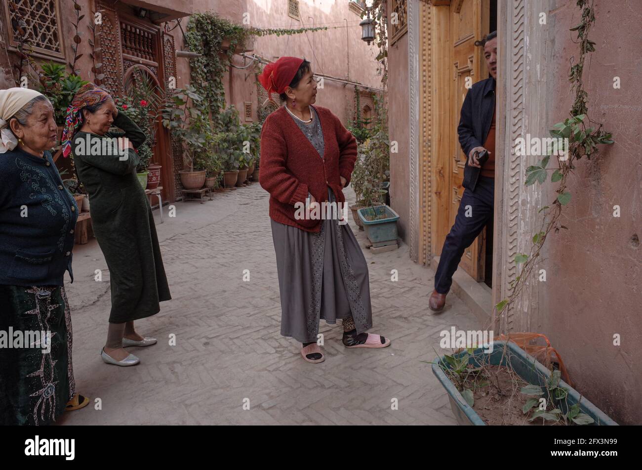 · 3 donne del gruppo etnico Uygur si confrontano con un uomo che lascia una casa. Repubblica popolare cinese del Kashgar 2019 Foto Stock