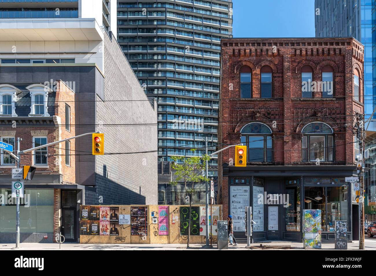 Trasformazione di Queen Street West a Toronto, Canada. Un piccolo e antico edificio storico rimane solo all'angolo con Peter Street. Il l Foto Stock