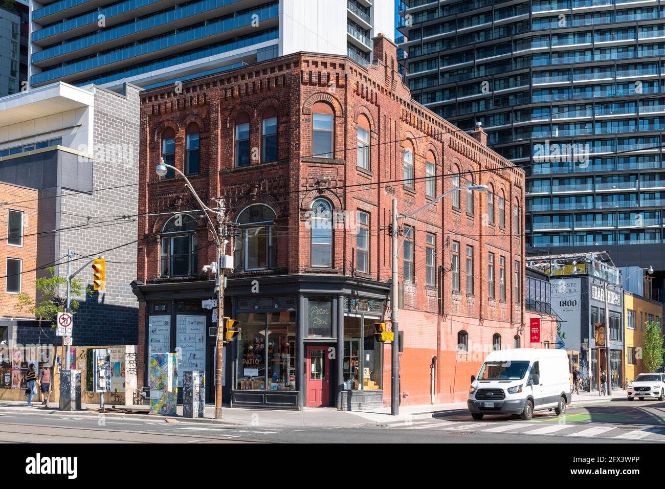 Trasformazione di Queen Street West a Toronto, Canada. Un piccolo e antico edificio storico rimane solo all'angolo con Peter Street. Il l Foto Stock