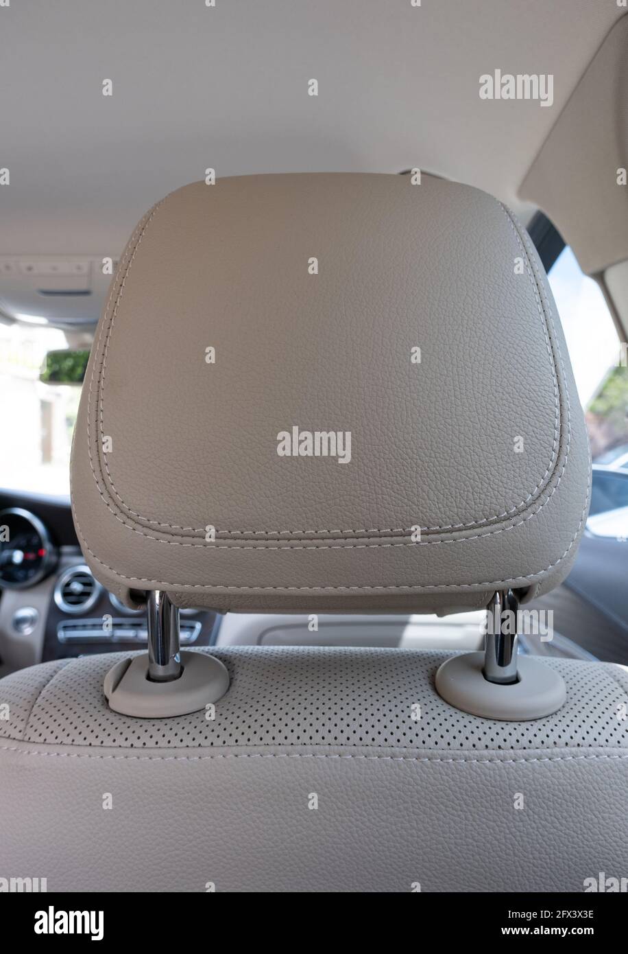poggiatesta in una comoda auto moderna e lussuosa con traforato beige pelle Foto Stock