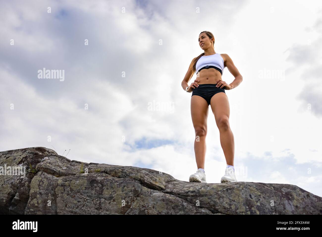 Fit Woman in piedi sulla roccia durante l'allenamento all'aperto Foto Stock