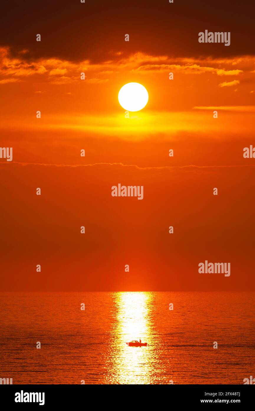 Motoscafo in mare fermo al tramonto Foto Stock