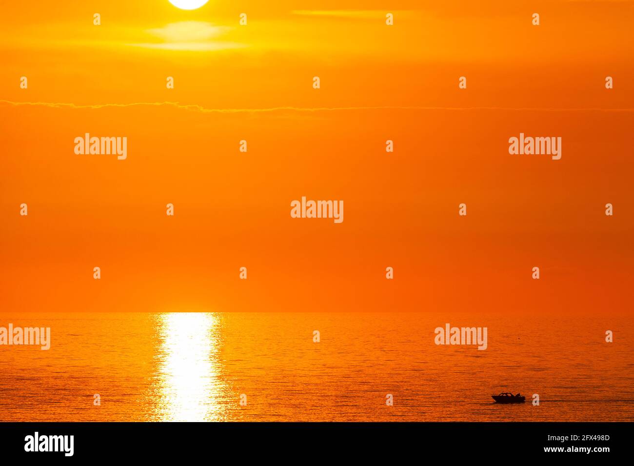 Motoscafo in mare fermo al tramonto Foto Stock