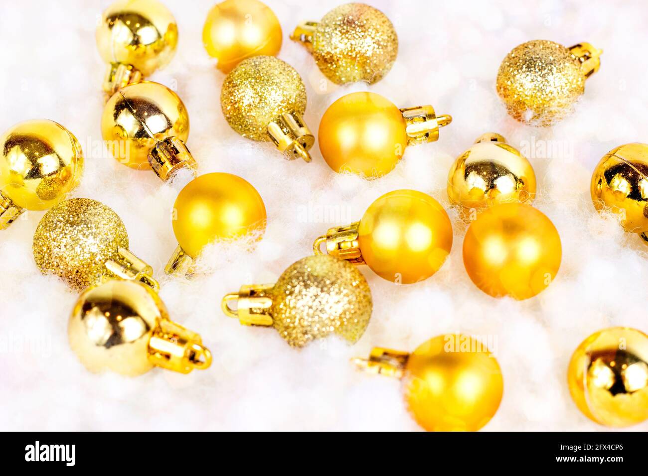 Decorazioni natalizie in oro brillante (nastri, baubles, archi, ornamenti) piatte su bianco fondo di neve artificiale. Natale e Capodanno tradizionale Foto Stock
