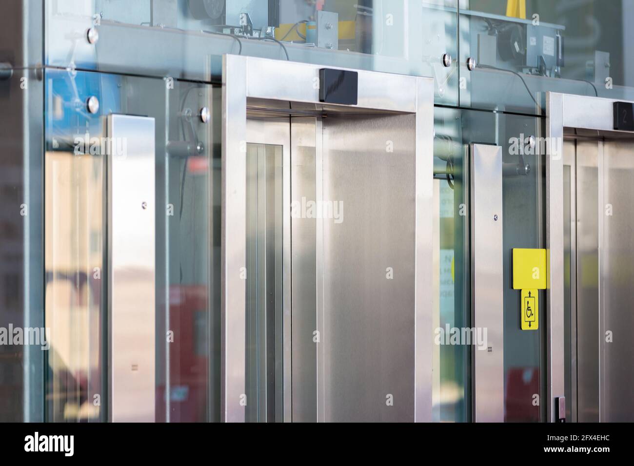 Meccanismi e dettagli dell'ascensore di vetro all'aeroporto. Vista attraverso il vetro. Foto Stock