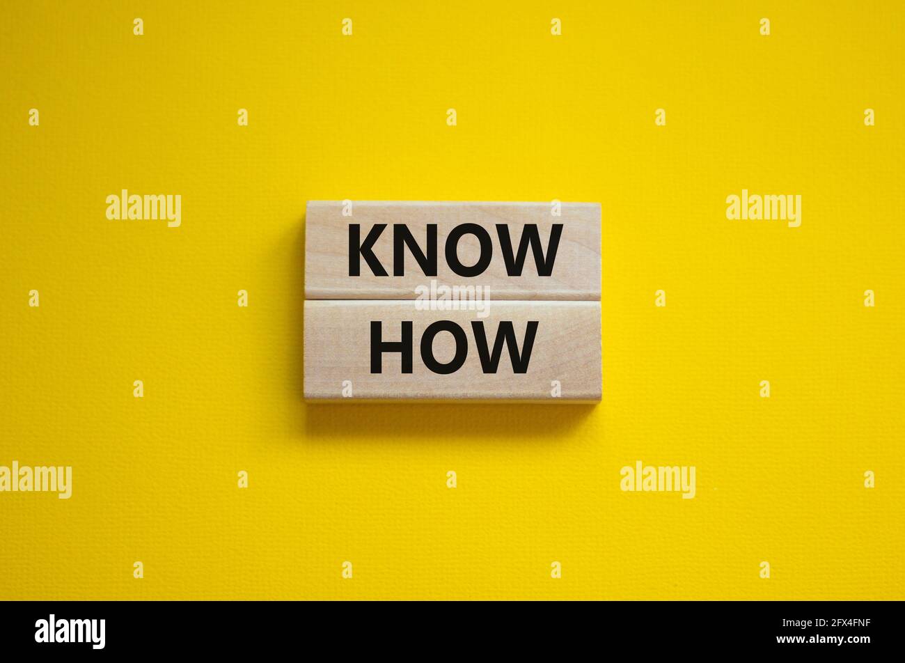Conoscere il simbolo. Blocchi di legno con parole 'know how' su bello sfondo giallo, copia spazio. Business, innovazione e know how concetto. Foto Stock