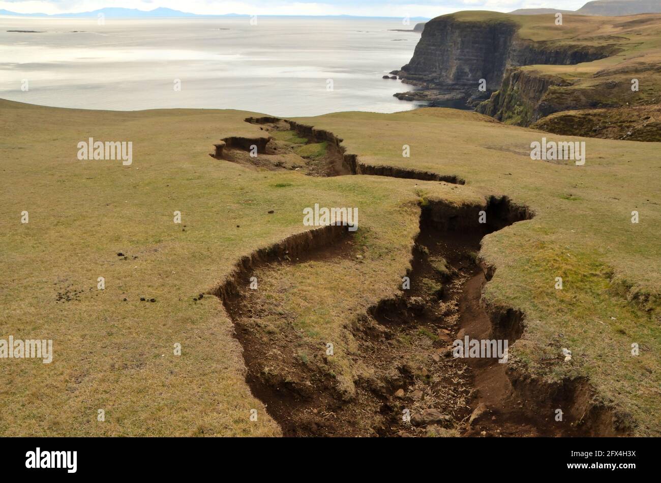 Una grande spaccatura nel terreno sopra le scogliere del mare sulla costa occidentale dell'Isola di Skye, Scozia, Isole Britanniche. Foto Stock