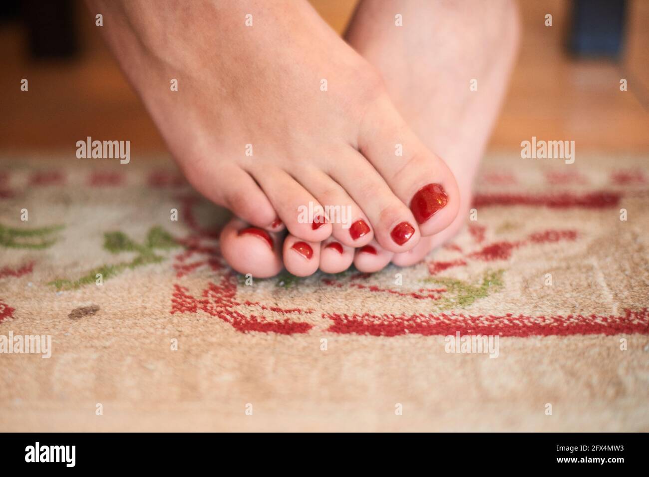 smalto per unghie sul piede donna. ragazza con pedicure rosso fresco in  piedi sul tappeto Foto stock - Alamy