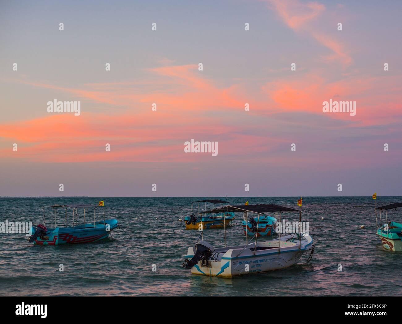 Barche da pesca in mare con nuvole rosa dopo il tramonto, spiaggia di Pasikuda, Kalkudah, Sri Lanka Foto Stock