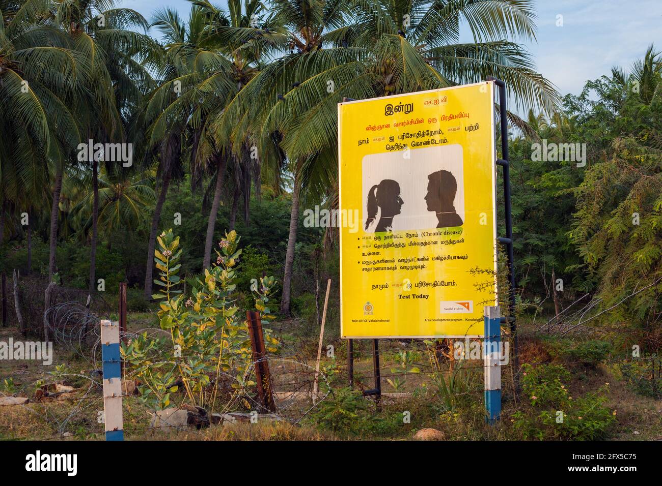 Billboard sulla strada paese avvertimento di coppie con 'malattia cronica' e consigliare a 'Test Today', Kalkudah, Provincia Orientale, Sri Lanka Foto Stock