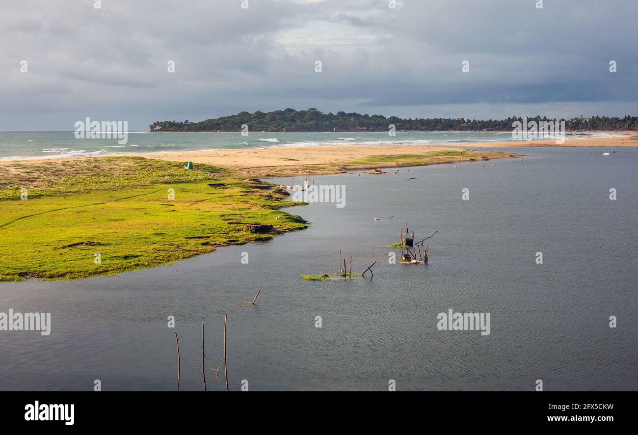 Arugam Bay e Arugam Lagoon separati da spiaggia e erba in un giorno tempestoso, Provincia del Nord, Sri Lanka Foto Stock