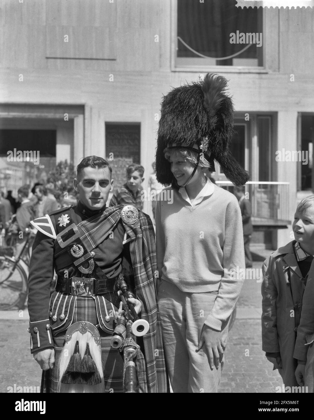 Prove generali per il Tattoo della NATO ad Arnhem. Ragazza con cappello da orso accanto a Scotsman, 11 luglio 1960, capo, bambini, Militare, prove, tatuaggi, Paesi Bassi, foto agenzia stampa del XX secolo, notizie da ricordare, documentario, fotografia storica 1945-1990, storie visive, Storia umana del XX secolo, che cattura momenti nel tempo Foto Stock