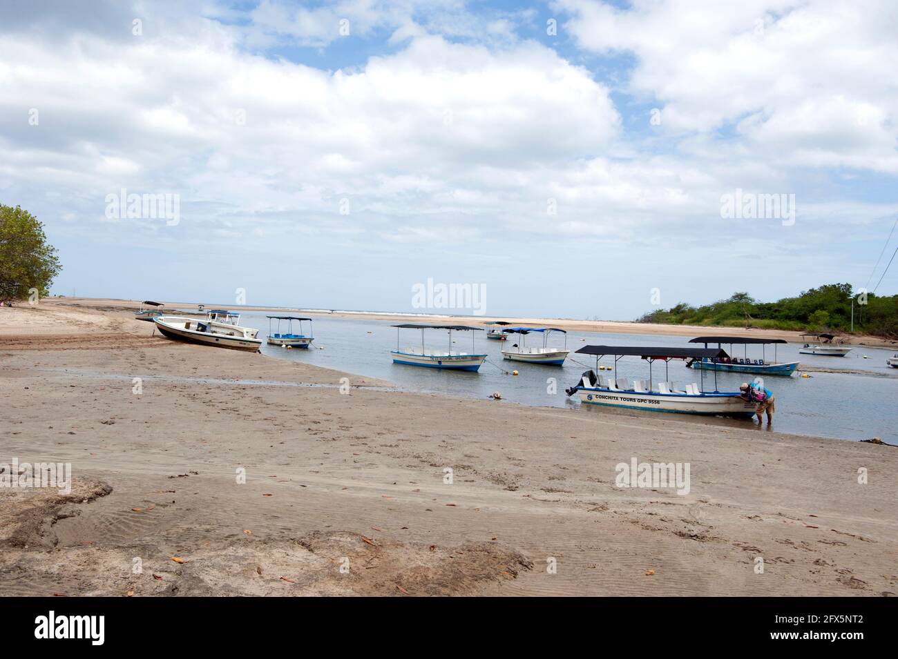 Tour in barca in attesa di clienti alla foce del fiume nell'Oceano Pacifico che conduce al Parque Nacional Marino Las Baulas a Tamarindo, Costa Rica Foto Stock