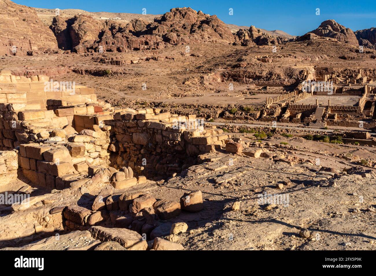 Parete parzialmente ricostruita del tempio dei leoni alati di fronte al grande tempio, con tombe sullo sfondo del sito archeologico storico di Petra, Giordania Foto Stock