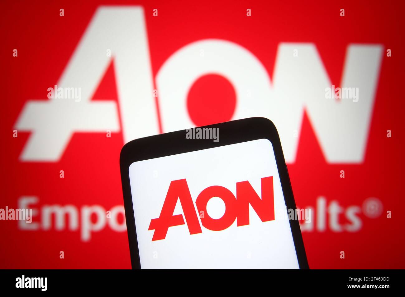 In questa illustrazione fotografica, il logo Aon di una compagnia di  assicurazioni viene visualizzato su uno smartphone e uno schermo del pc  Foto stock - Alamy