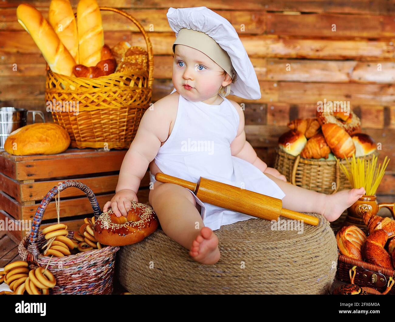 bambino ragazzo panettiere in un cappello dello chef e grembiule con un  grande sacchetto in mano sorride sullo sfondo di prodotti da forno Foto  stock - Alamy