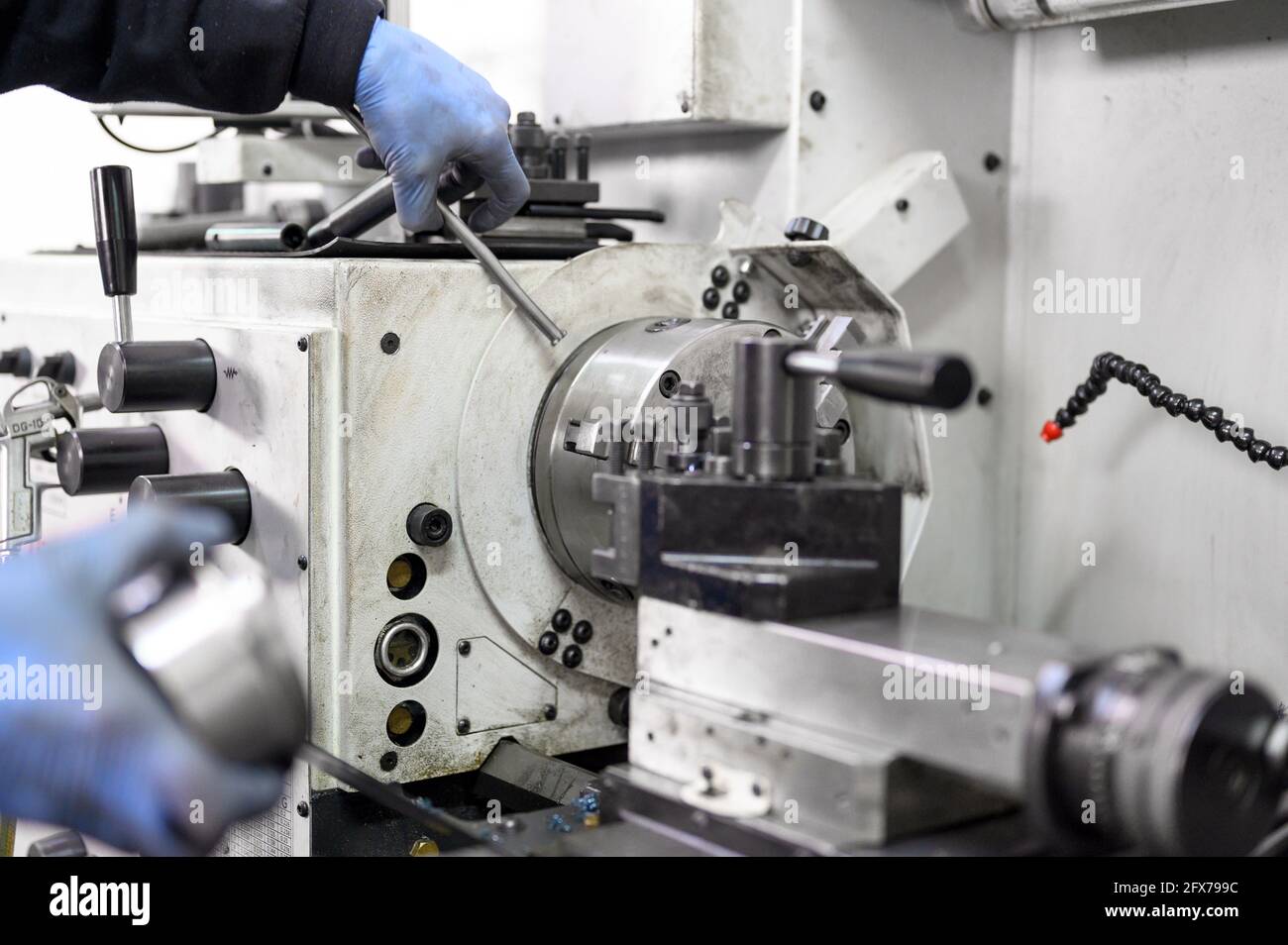 Vista ravvicinata del lavoratore che lavora con un'operazione di tornitura ad alta precisione su un tornio multiasse, macchina utensile CNC. Foto di alta qualità. Foto Stock