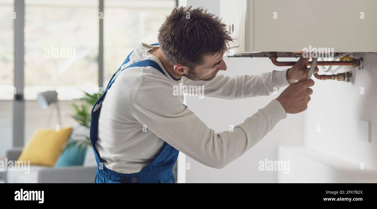 Controllo professionale dell'idraulico di caldaie e tubazioni, concetto di servizio caldaia Foto Stock