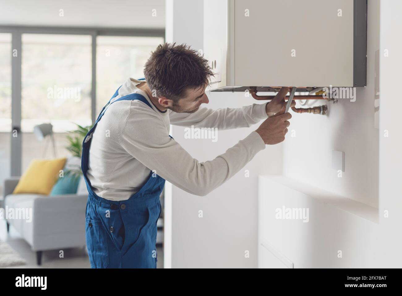 Controllo professionale dell'idraulico di caldaie e tubazioni, concetto di servizio caldaia Foto Stock