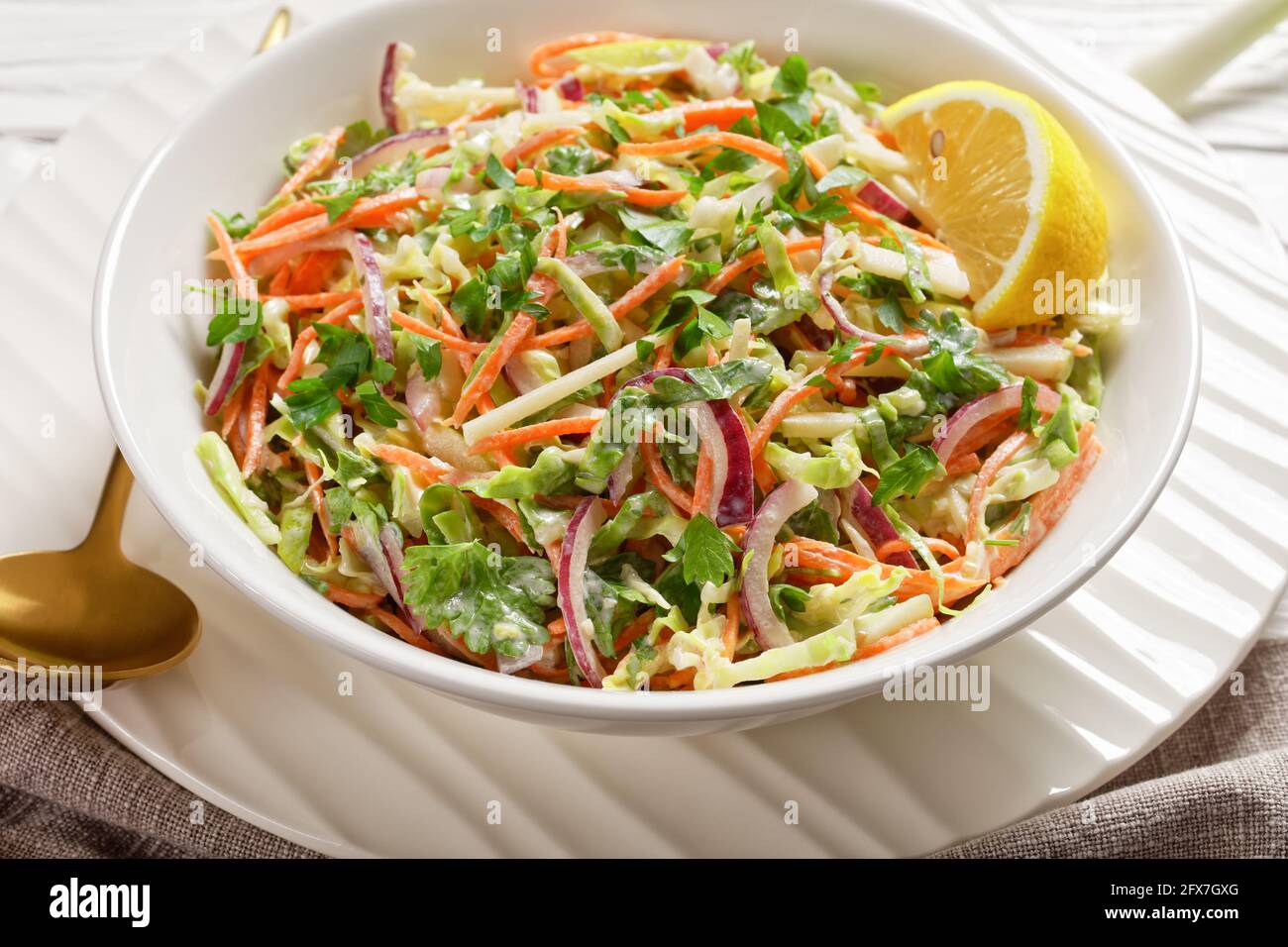 insalata fresca estiva di insalata di insalata di coleslaw con leggero yogurt in una ciotola bianca su un tavolo di legno, primo piano Foto Stock