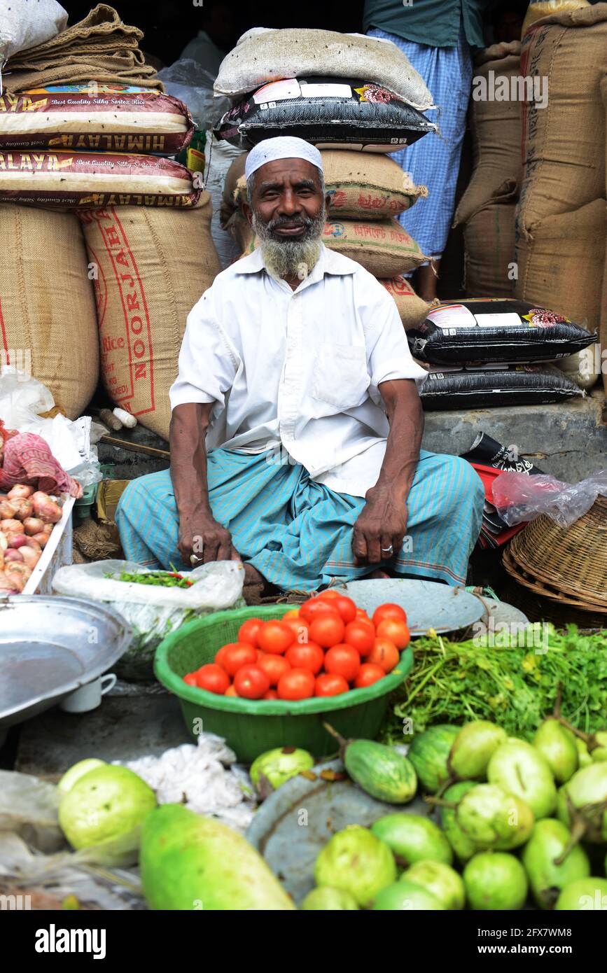 Un venditore di ortaggi del Bangladesh che vende i suoi prodotti nella zona del bazar di Chowk a Dhaka, in Bangladesh. Foto Stock