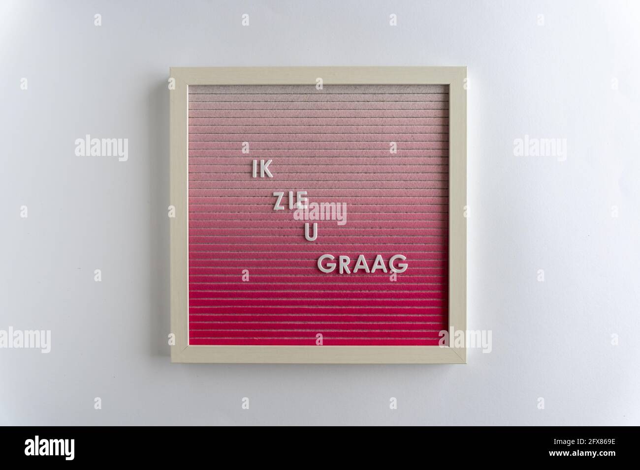Rosa Letterboard parole che Scrivi Ik Zie U GRAAG (traduzione: Ti amo), su sfondo bianco, orizzontale Foto Stock