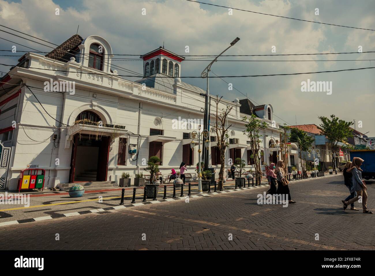 Giovani donne che attraversano una strada nella parte vecchia di Semarang City, conosciuta popolarmente come 'Kota lama' (Città Vecchia), un sito patrimonio culturale che è in parte sviluppato durante l'epoca coloniale. Semarang, Giava Centrale, Indonesia. Foto Stock