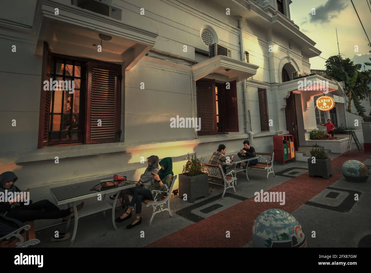 I giovani hanno tempo libero in un caffè lungo la strada nella parte vecchia di Semarang City, popolarmente conosciuta come 'Kota lama' (Città Vecchia), un sito patrimonio culturale che è in parte sviluppato durante l'epoca coloniale. Semarang, Giava Centrale, Indonesia. Foto Stock