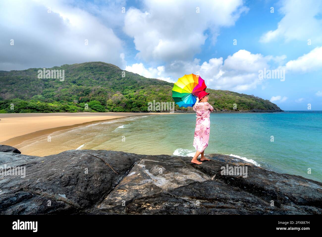 Con Isola di Dao nella Provincia di Ba Ria-Vung Tau, Vietnam - 11 aprile 2021: Turista femminile con un ombrello colorato su una scogliera sulla spiaggia di con Dao islan Foto Stock